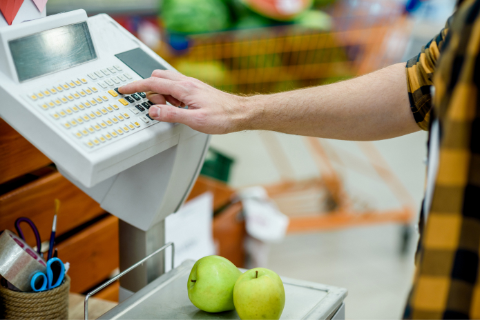 cashier at grocery store using the register