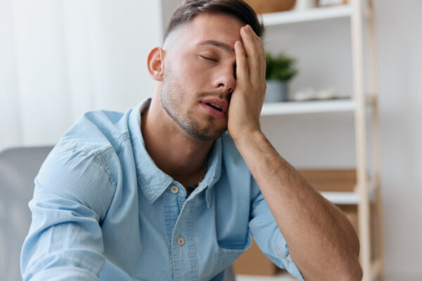 Tired young man resting his head on his hand