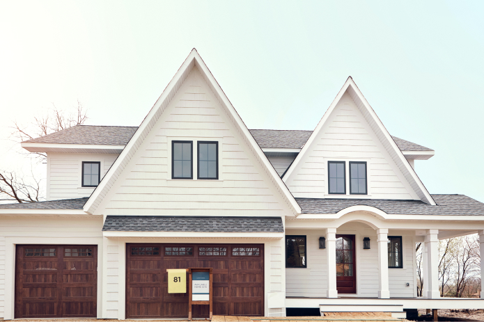 pretty white custom home with a wrap around front porch